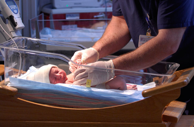 Male nurse with newborn baby